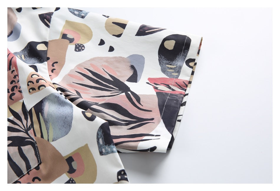 Close-up of the shirt's short sleeve and stitched cuff, with the light-background abstract print.