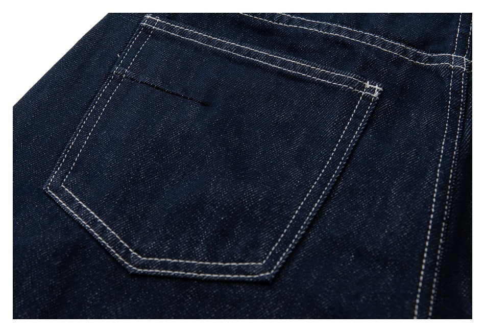 Close-up of a back pocket on dark indigo jeans with contrasting double stitching.