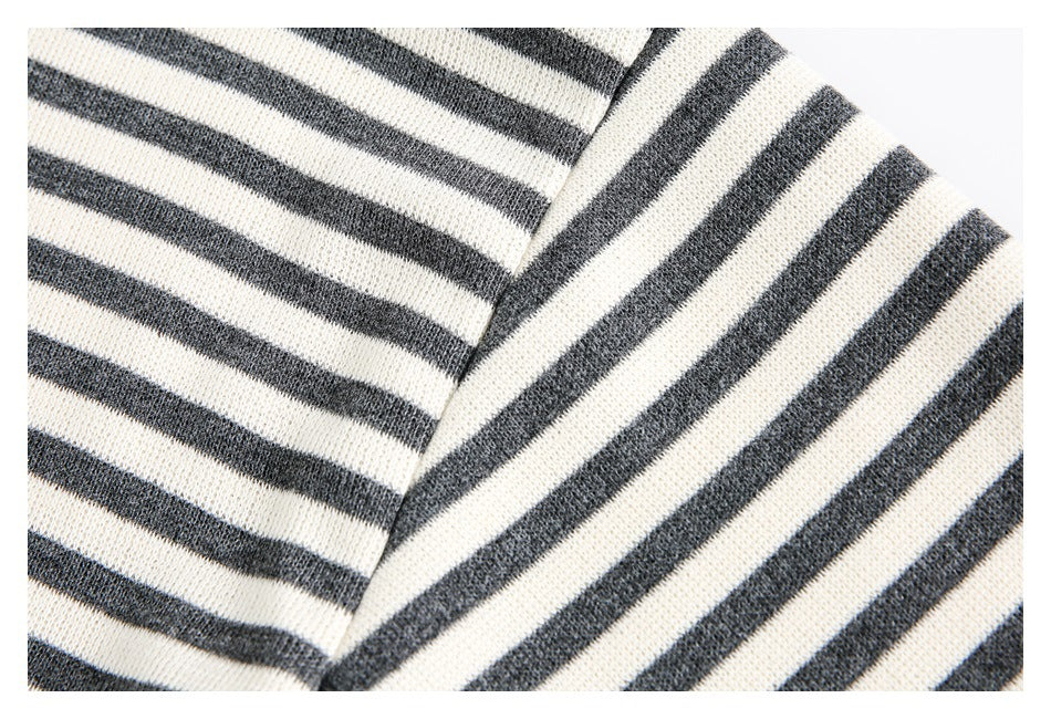 Close-up of cream and charcoal stripes crossing at an angled garment seam.