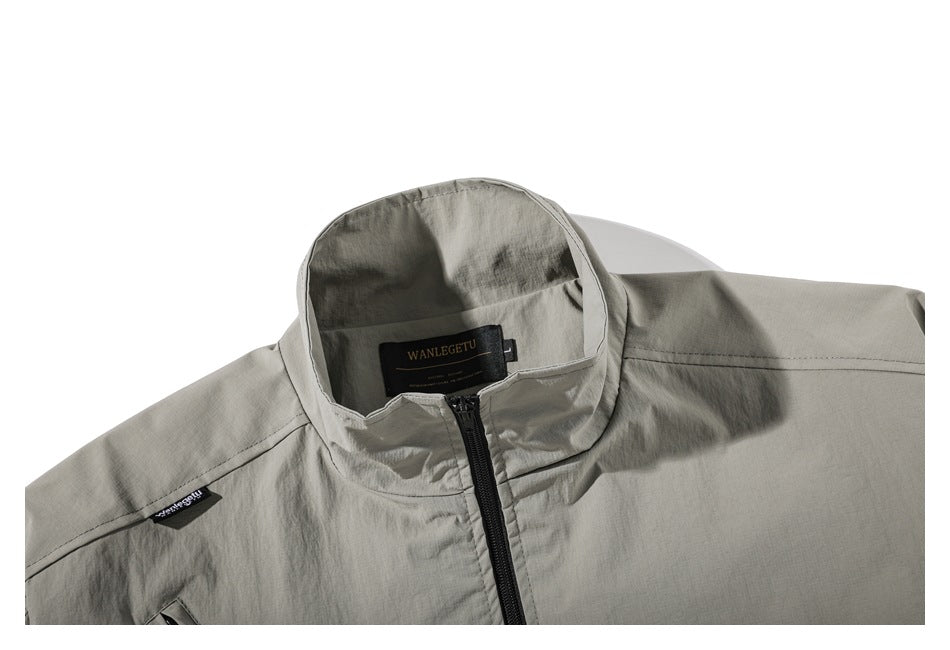 Close-up of a light gray-green jacket collar, black front zipper, and sewn neck label.