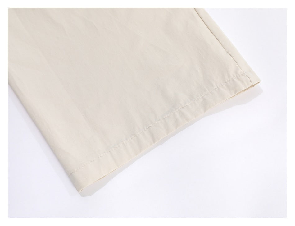 Close-up of the stitched hem on an ivory trouser leg.