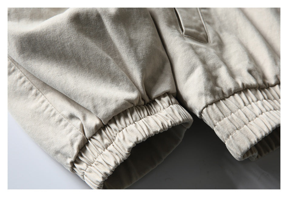 Close-up of gathered elastic cuffs on the sleeves of a light beige jacket.