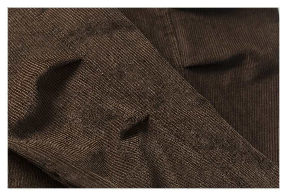 Close-up of brown corduroy with two horizontal buttonholes and visible ribbed texture.