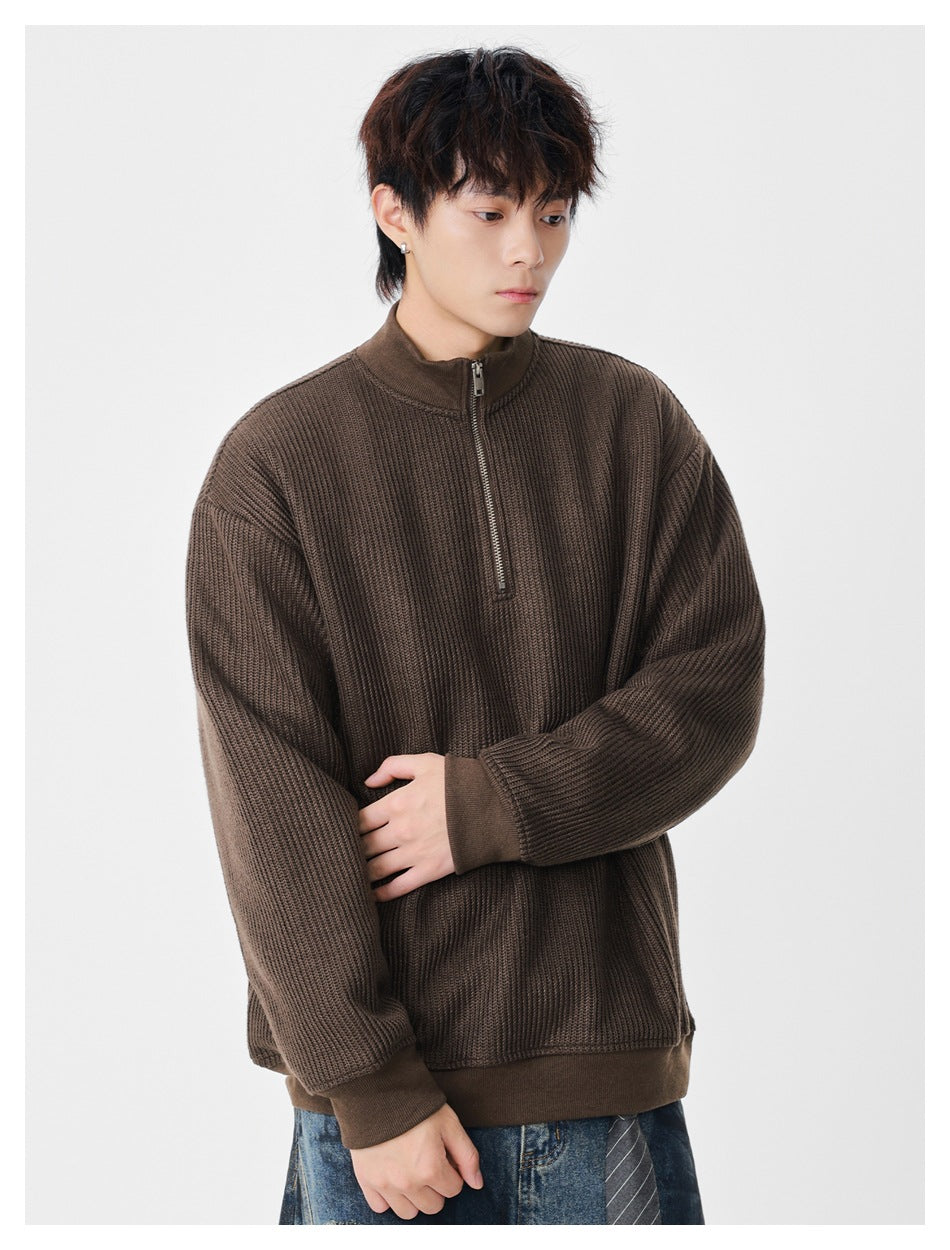 Model wearing a brown textured half-zip pullover with a stand collar and ribbed cuffs and hem.