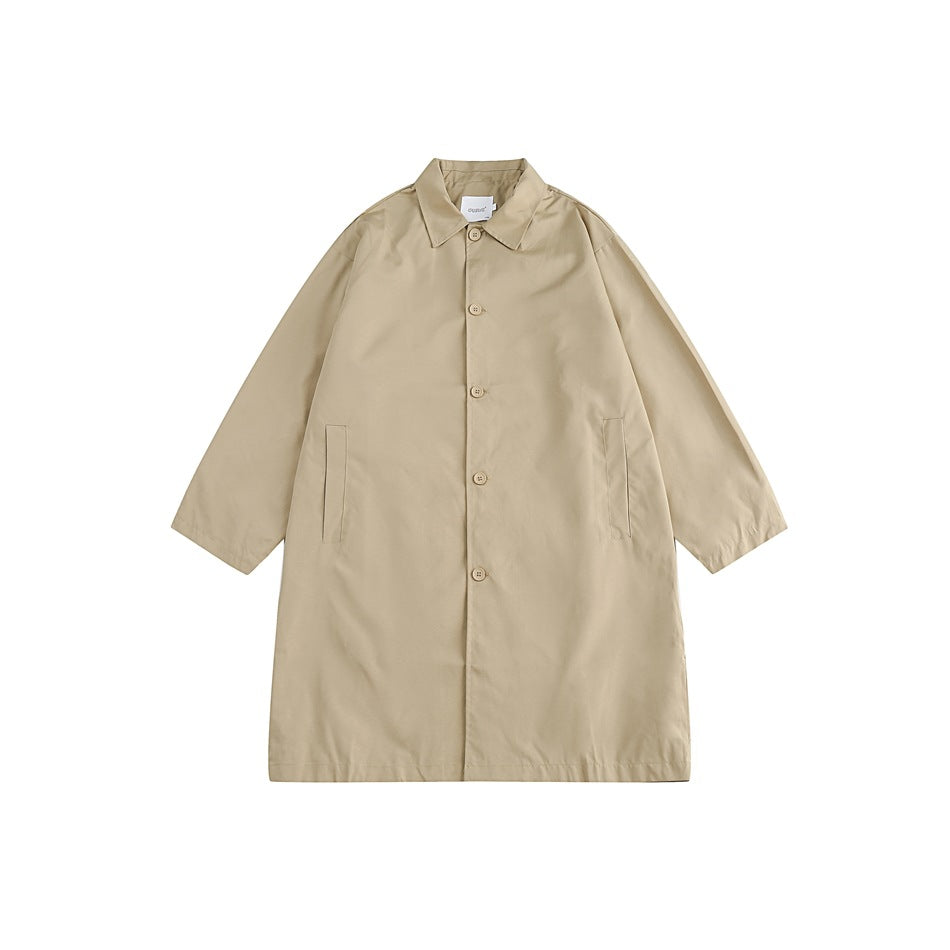 Front view of a beige long coat with a pointed collar, button fastening, and two welt pockets.