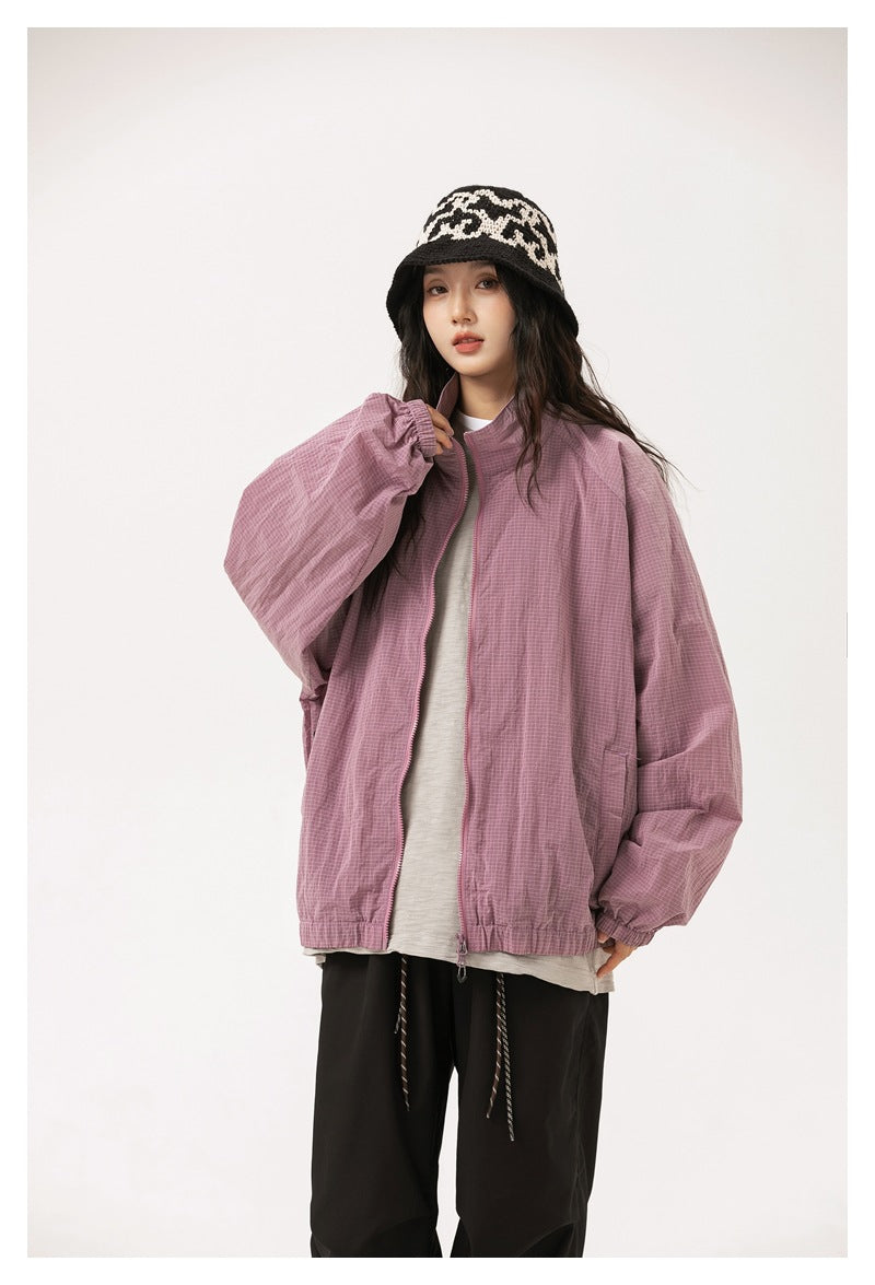 Model wearing a mauve oversized zip jacket with a raised collar and elastic hem.