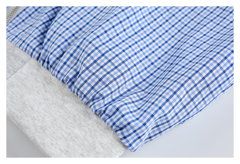 Blue-and-white gingham fabric gathered along a seam above a light gray knit band.