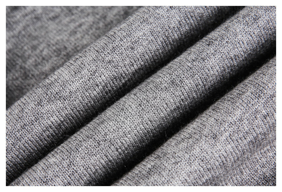 Close-up of gray knitted fabric arranged in soft folds, showing its fine looped texture.
