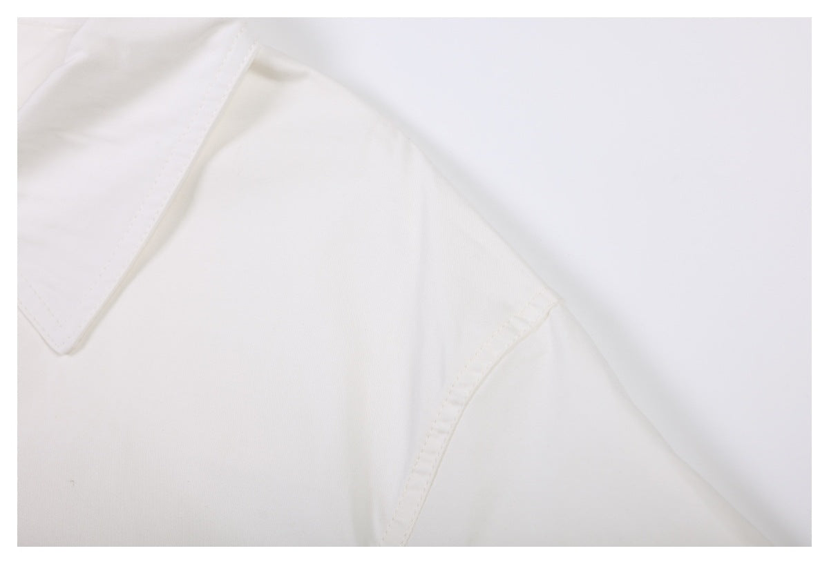 Close-up of the white garment's collar and shoulder seam.
