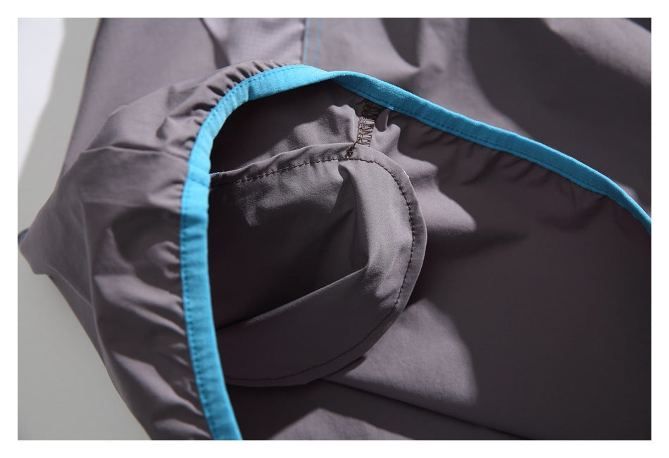Close-up of the garment's interior seam and curved gray panel edged with bright blue binding.