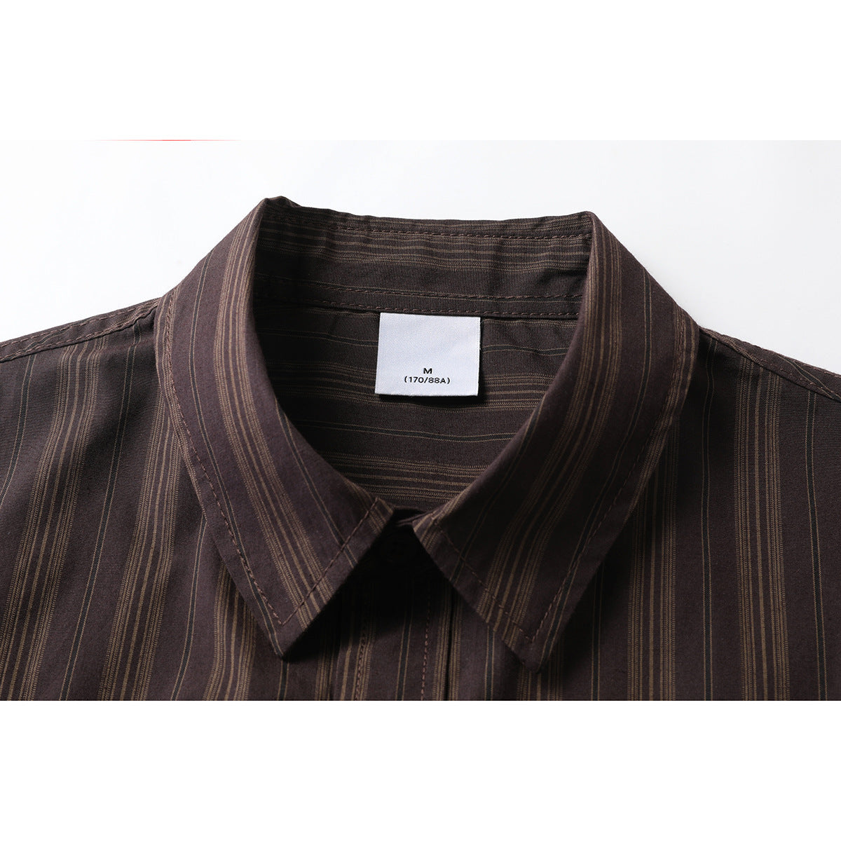 Close-up of a dark brown vertically striped shirt collar with a white M size label.