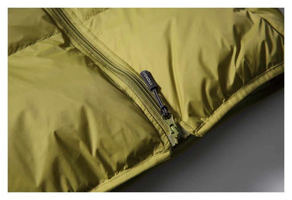 Close-up of an olive-yellow padded jacket zipper and branded pull tab.