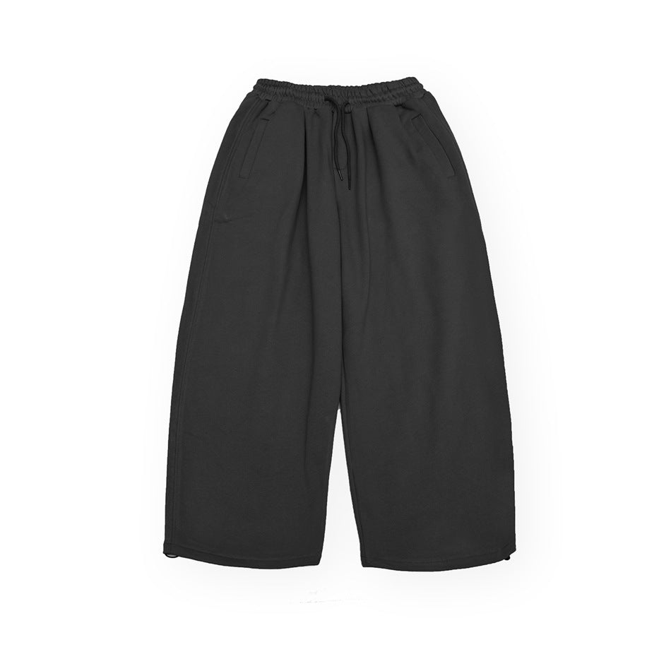 Black-gray wide-leg drawstring pants with elastic waist and side pockets, flat lay front view