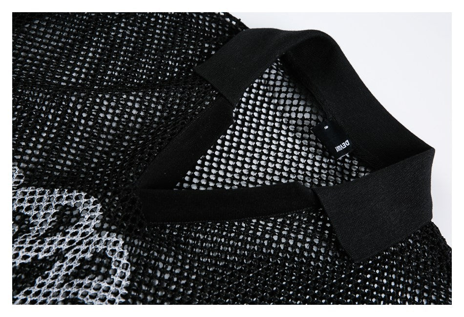 Close-up of a black open-knit garment's ribbed neckline and small woven label.