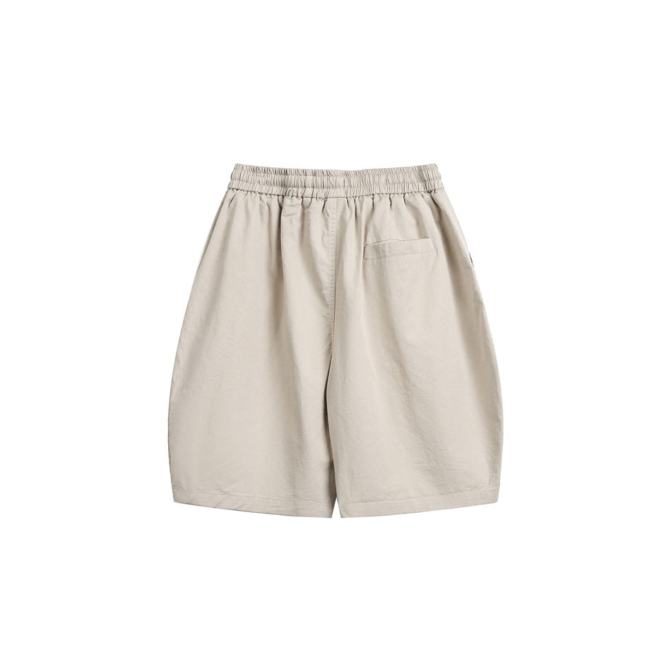 Back view of khaki shorts with elastic waistband and a single welt-style back pocket on white background