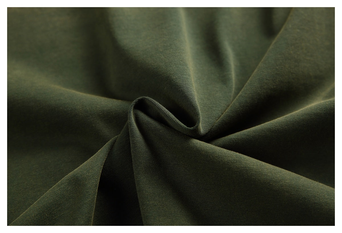 Close-up of dark olive-green fabric gathered into folds, showing its surface texture.