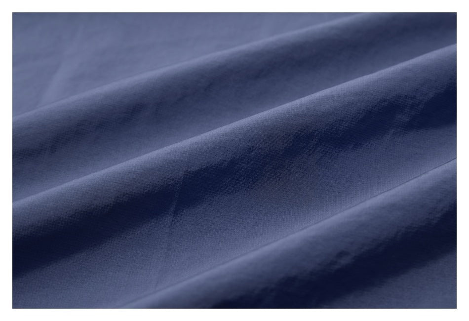 Macro view of the blue jacket fabric, showing its fine surface texture and folds.