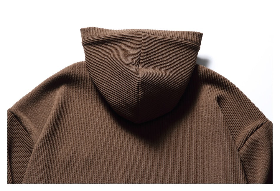 Back view of a brown ribbed hooded sweatshirt, showing the hood, shoulders, and upper back.