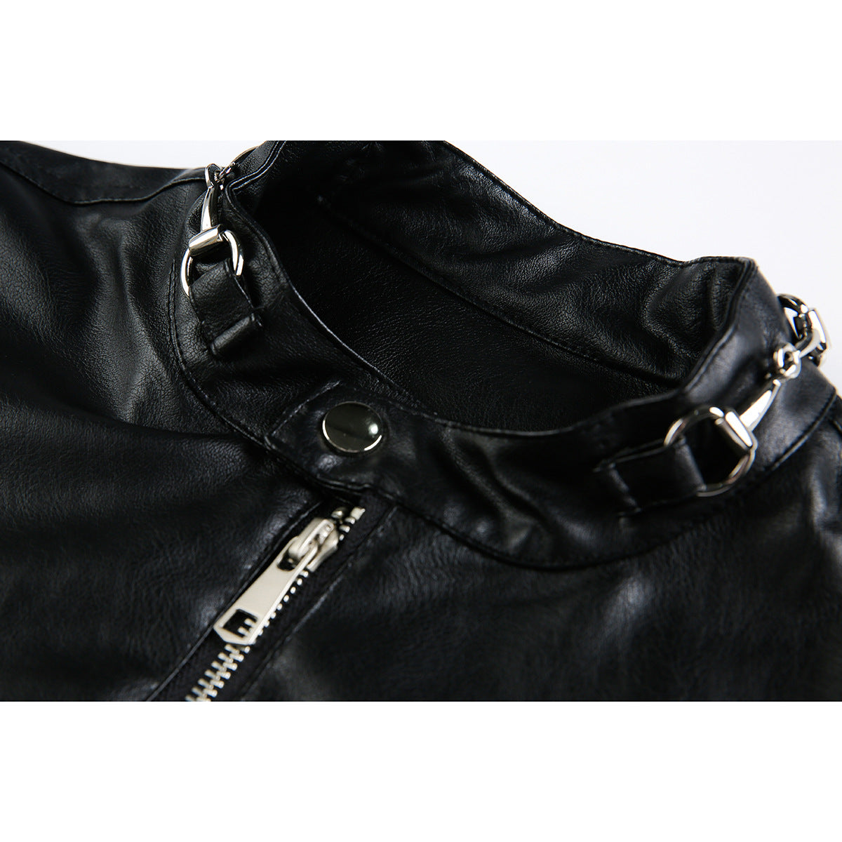 Close-up of a black jacket collar with silver ring hardware, a snap tab, and an angled zipper.