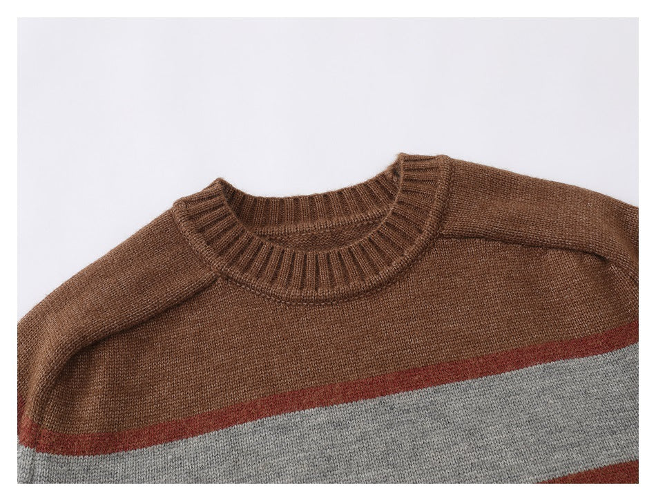 Close-up of a brown ribbed crew neckline above rust and gray stripes on a knit sweater.