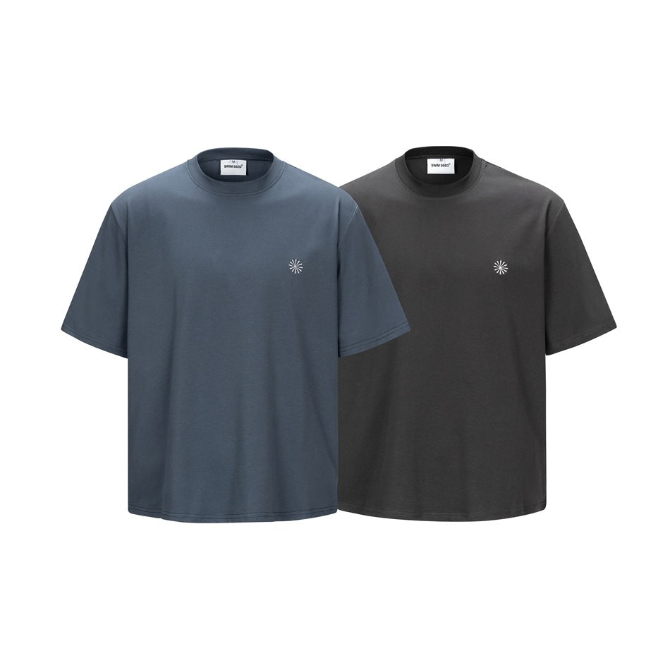 Two short-sleeve crew-neck T-shirts shown from the front in slate blue and charcoal, each with a small white chest emblem.