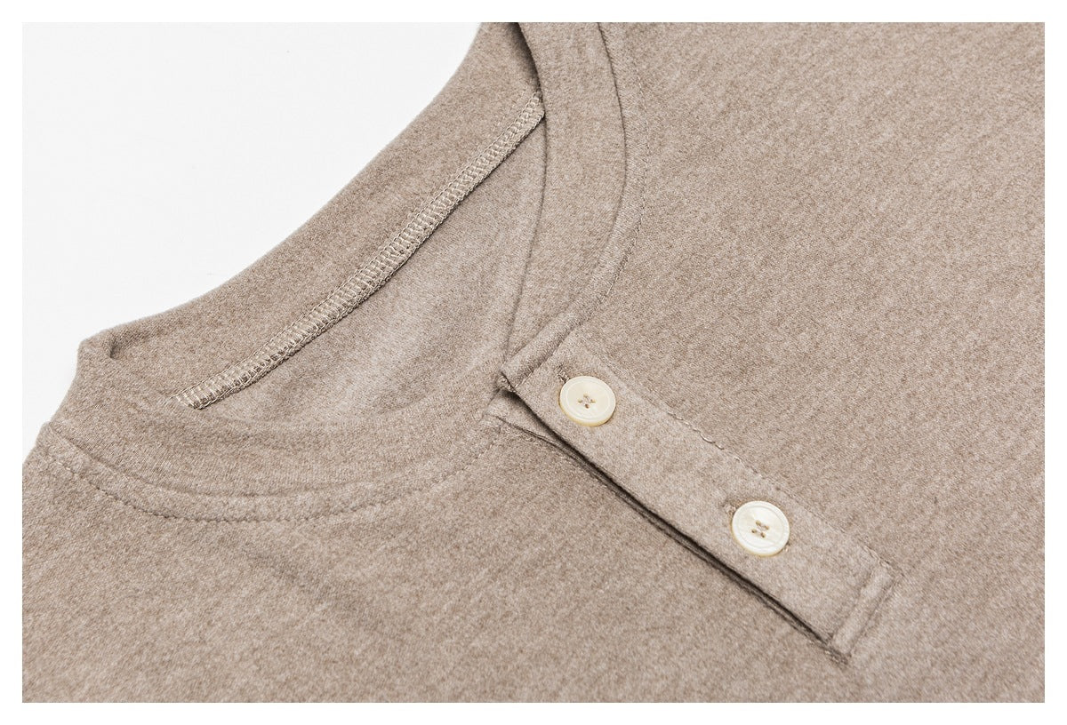 Close-up of a taupe top's neckline and two-button placket with visible inner stitching.