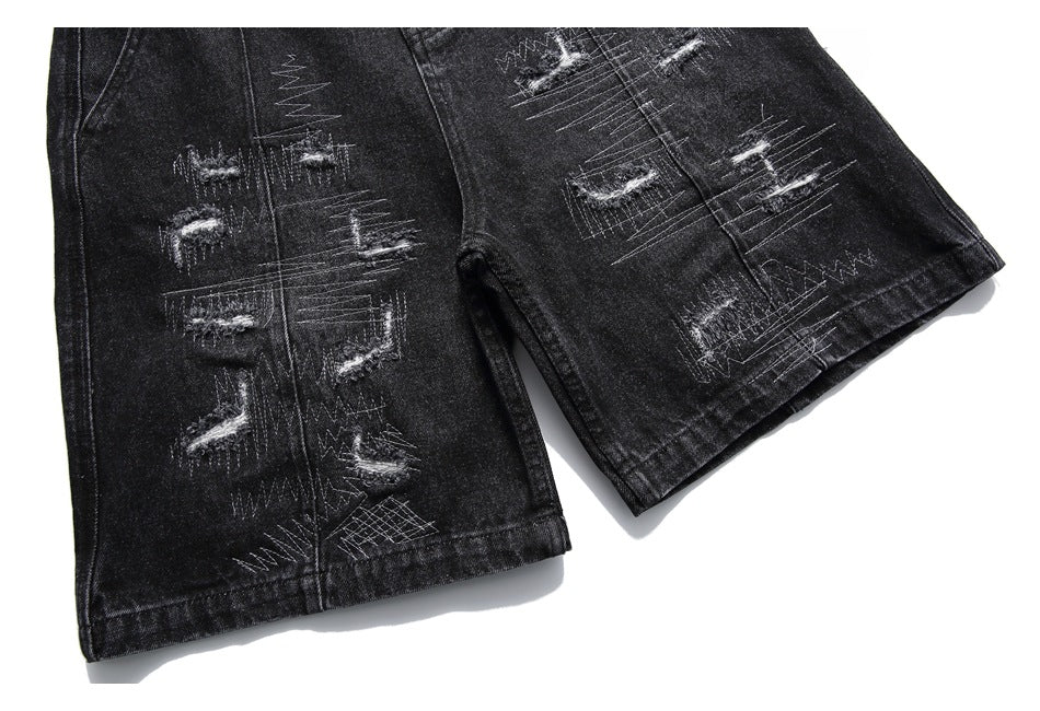 Cropped front view of black denim shorts showing both legs with distressed stitched detailing.