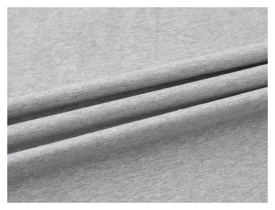 Close-up of light gray knit fabric arranged in soft folds.
