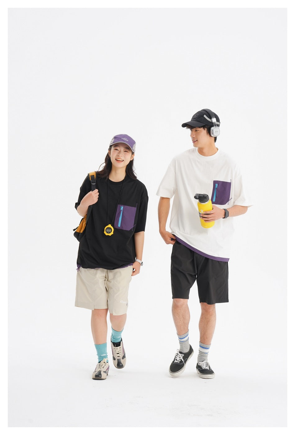 Two models wearing black and white oversized T-shirts with purple zip chest pockets and contrasting shorts.