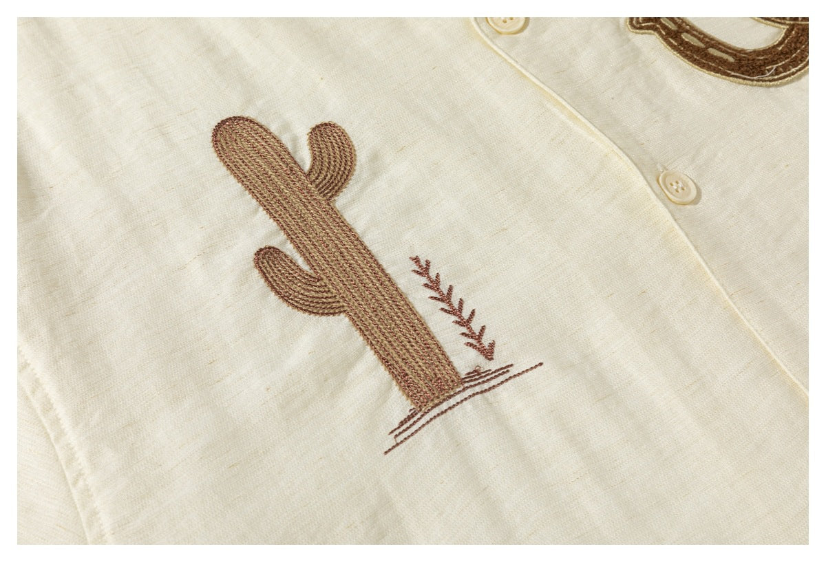 Close-up of a brown cactus and sprig embroidery on a cream button-front shirt.