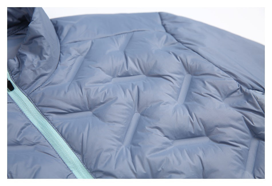 Close-up of slate-blue padded jacket panels with stitched quilting and part of the pale aqua zipper.
