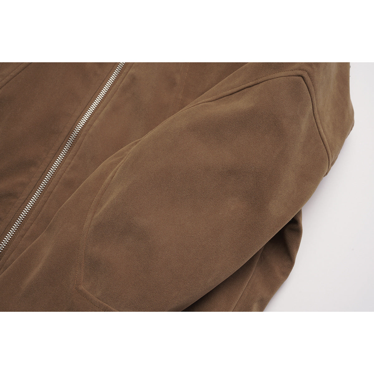 Close-up of a brown jacket sleeve and front with visible stitching and a silver zipper.