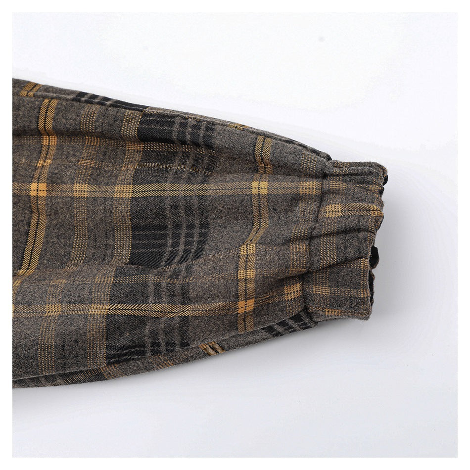 Close-up of a gray-brown plaid sleeve ending in a gathered cuff.