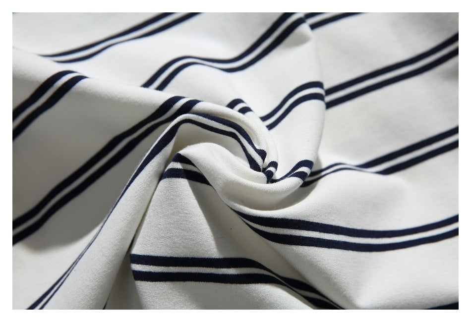 Close-up of white fabric with navy stripes twisted into a gathered fold.