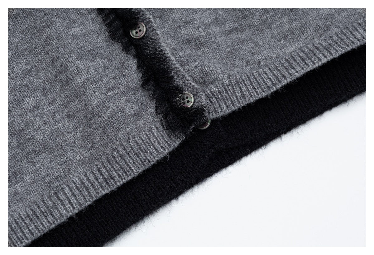 Close-up of the gray cardigan's ribbed hem, buttons, and black ruffle-trimmed front over a black layer.