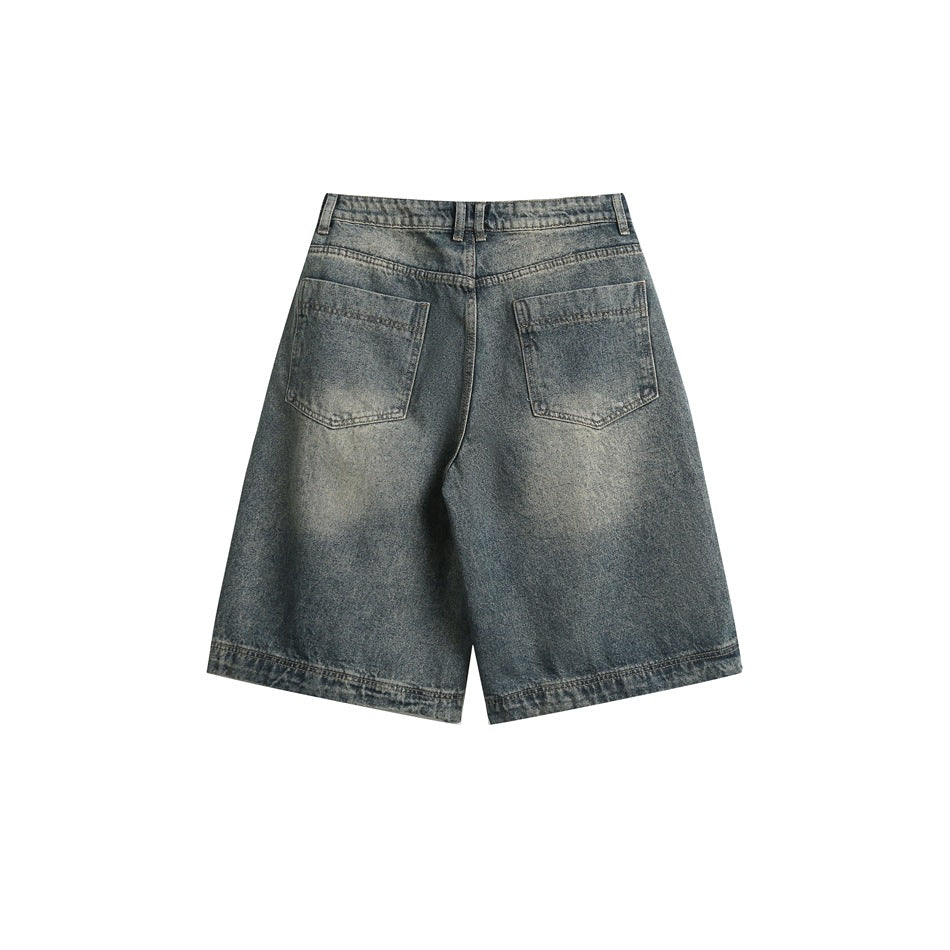 Back view of oversized faded denim shorts with two patch pockets and a wide hem, shown against a white background.