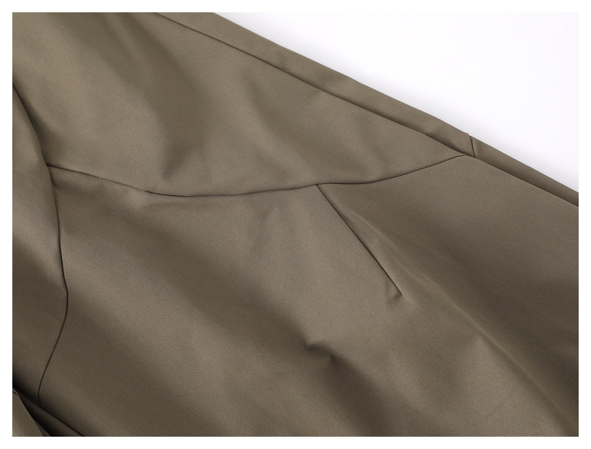 Close-up of taupe trouser fabric and curved panel seams.