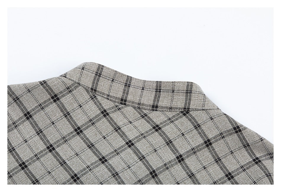 Close-up of a collar and plaid fabric in gray-beige with dark intersecting lines.