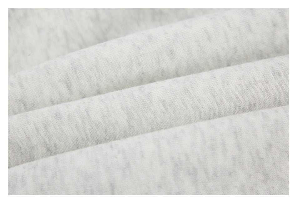 Close-up of pale gray fabric with a subtle mottled texture and folded layers.