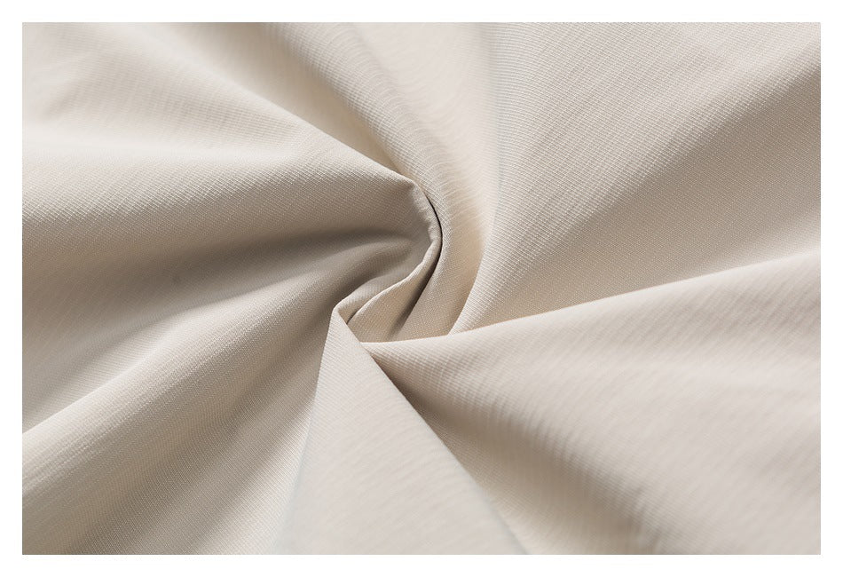 Close-up showing the fine, subtle texture of light beige fabric gathered into folds.
