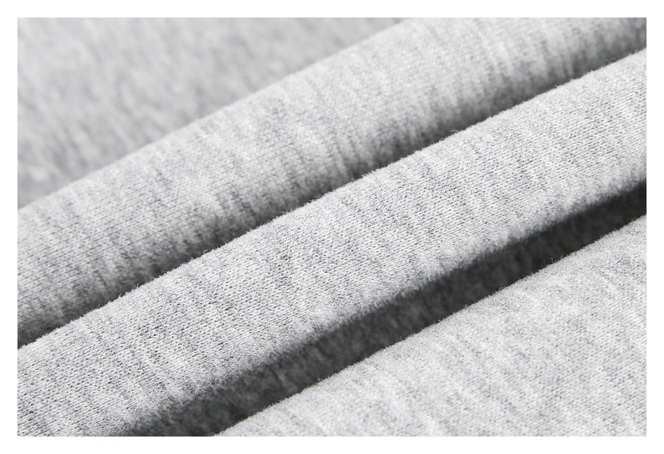 Close-up of light gray heathered fabric folded to show its knit texture.