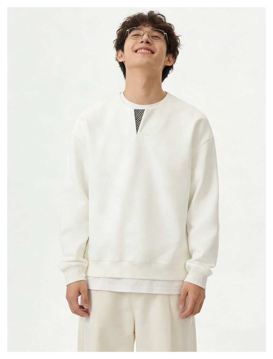 Front view of a model wearing an ivory sweatshirt with a small patterned neckline insert and matching pants.