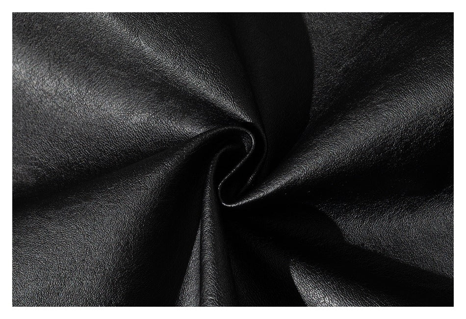 Macro view of glossy black leather-look material gathered into a fold.