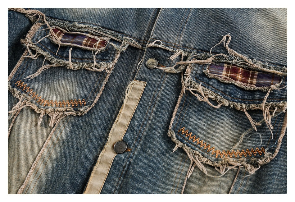 Close-up of the jacket's distressed denim back pockets with plaid accents and orange zigzag stitching.