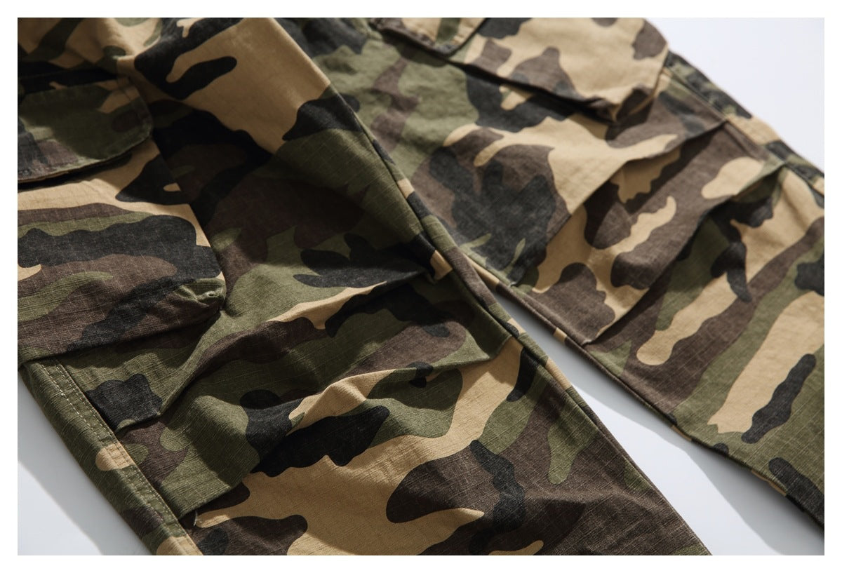 Close-up of camouflage trousers with multiple flap pockets and stitched panels.