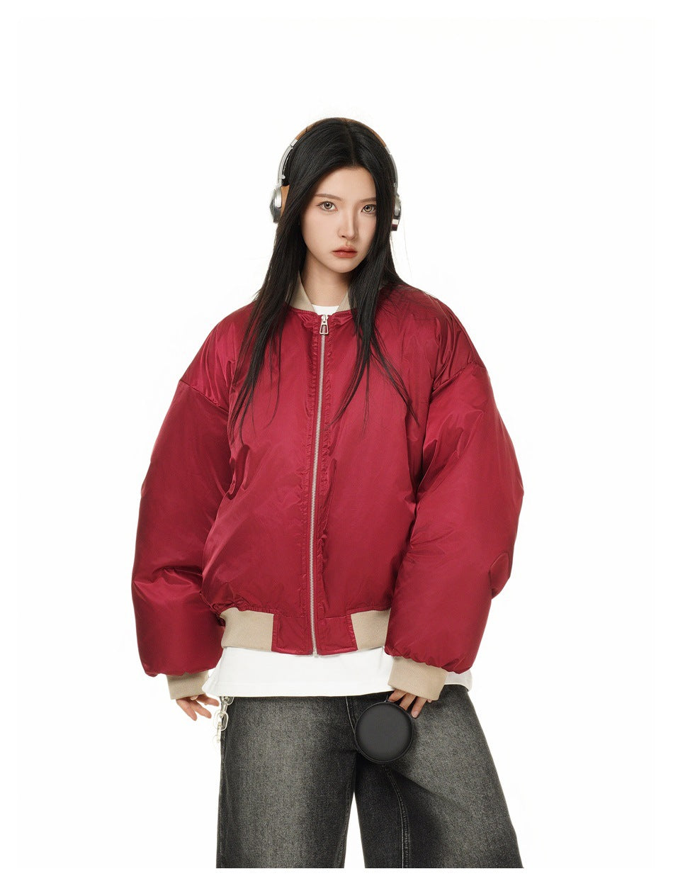 Model wearing a red oversized zip-front jacket with beige ribbed collar, cuffs and hem, shown from the front.