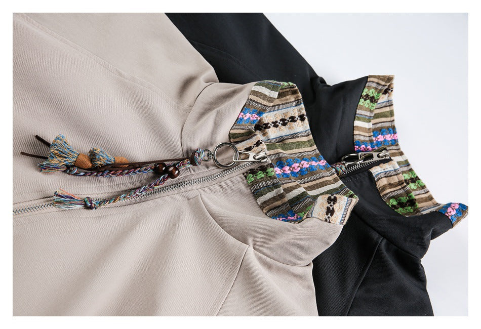 Close-up of beige and black zip-front jackets with striped multicolor collars and braided tassel zipper pulls.