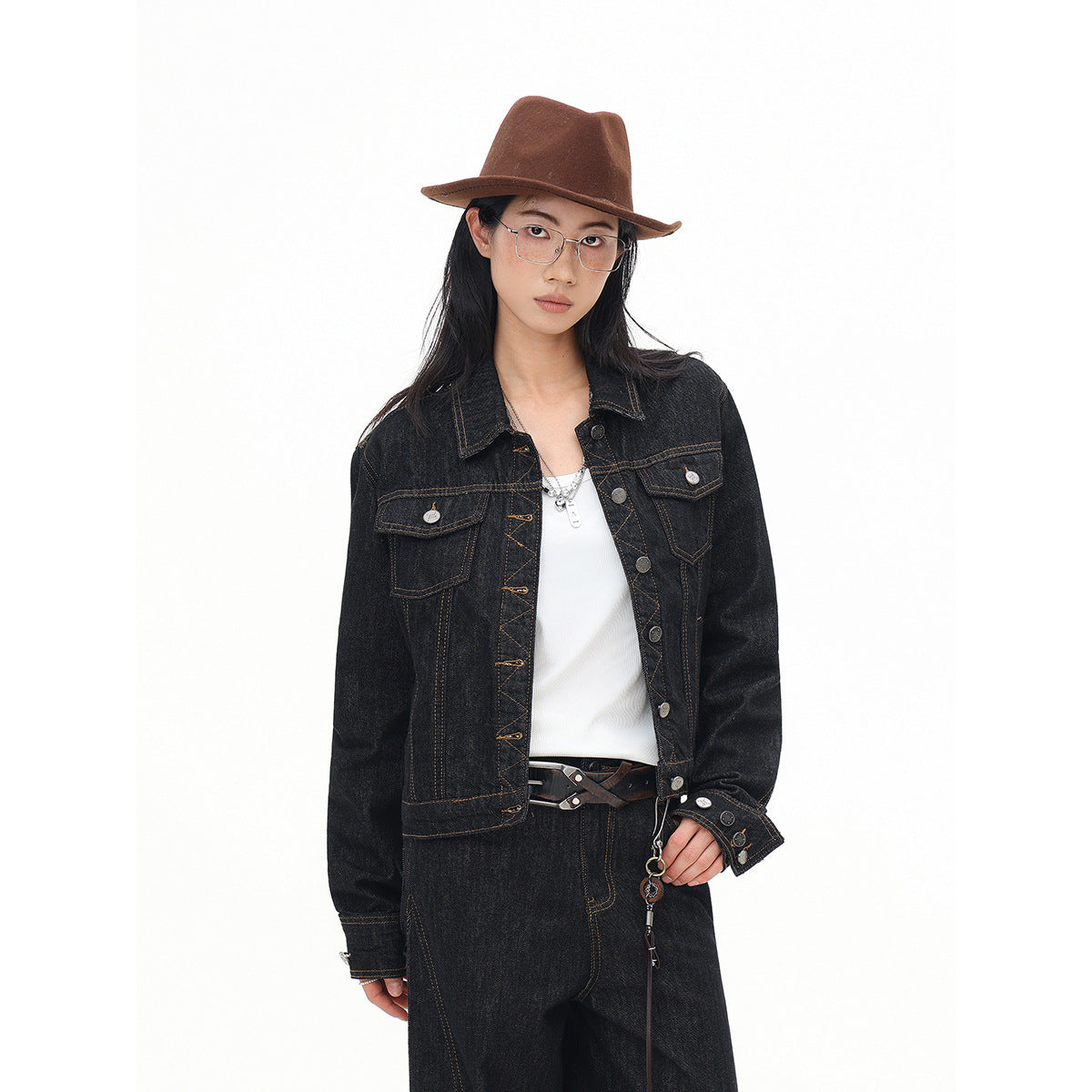 Model in a black denim jacket with contrast stitching and flap chest pockets, shown from the front.