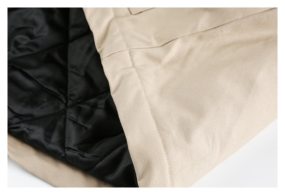 Close-up of beige garment hem and black quilted lining.