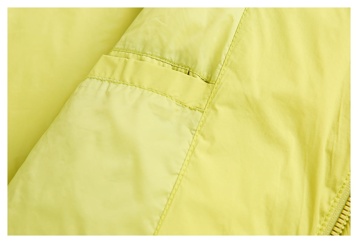 Close-up of pale yellow garment fabric with stitched panel seams and a partial zipper.